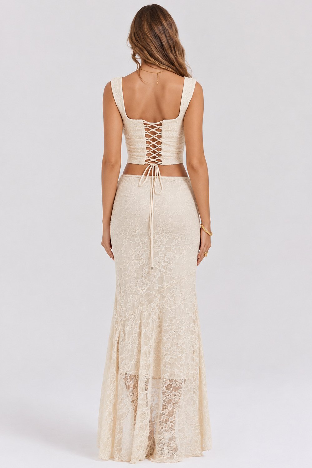 conjunto de renda off white vista de costas Costas do conjunto off white de renda, mostrando a amarração do cropped e a saia longa.